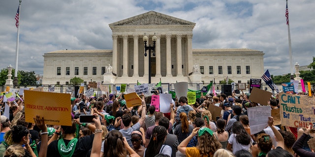 WASHINGTON, DC - JUNE 24: People protest in response to the Dobbs v Jackson Women's Health Organization ruling in front of the U.S. Supreme Court on June 24, 2022 in Washington, DC. 