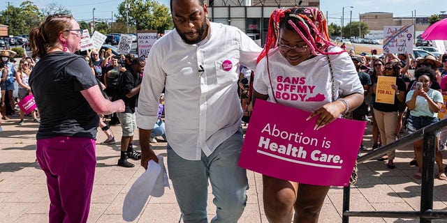 Democratic candidate for U.S. Senate Charles Booker walks with his eldest daughter, Kaylin Booker, during a press conference after addressing the Supreme Court's decision in the Dobbs v Jackson Women's Health case at  on June 24, 2022 in Louisville, Kentucky. 