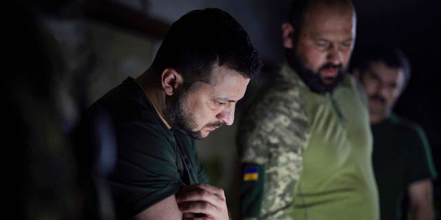 In this photo provided by the Ukrainian Presidential Press Office, Ukrainian President Volodymyr Zelenskyy, left, listens to a servicemen report close to the front line in Donetsk region, Ukraine, Sunday, June 5, 2022.