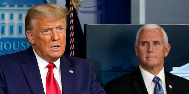 In this Nov. 24, 2020, file photo President Donald Trump speaks in the press briefing room as Vice President Mike Pence listens in Washington. 