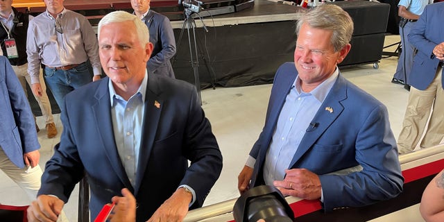 Former Vice President Mike Pence and Republican Gov. Brian Kemp of Georgia shake hands with supporters after Pence headlined a primary eve rally for Kemp, on May 23, 2022 in Cobb County, Georgia 