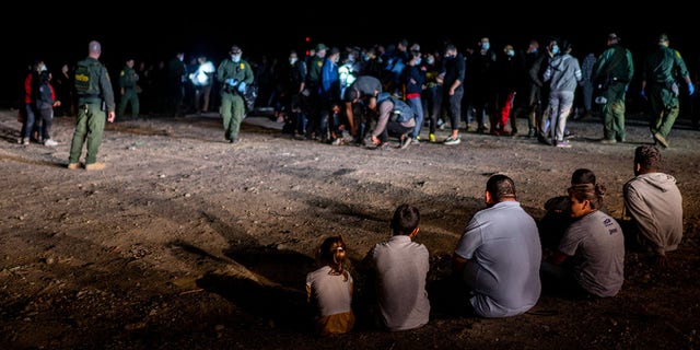 A migrant family sits after being processed in Roma, Texas, May 5, 2022.