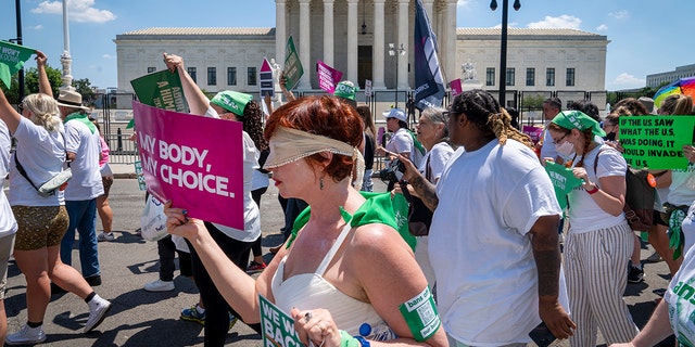 Mahayana Landowne, of Brooklyn, N.Y., wears a "Lady Justice" costume as she marches past the Supreme Court during a protest for abortion-rights, Thursday, June 30, 2022, in Washington. 