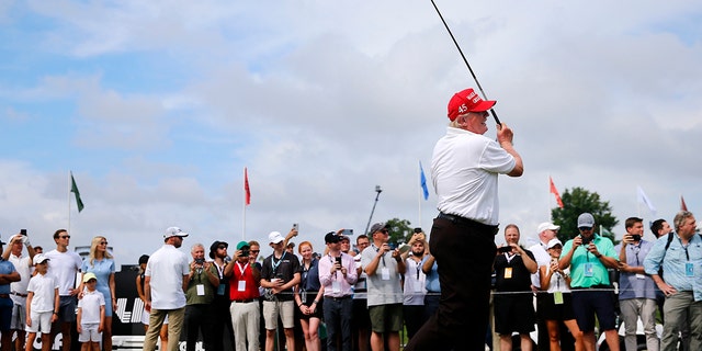 Former President Donald Trump watches his shot from the first tee during the pro-am prior to the LIV Golf Invitational at Trump National Golf Club in Bedminster, N.J., on Thursday, July 28, 2022.