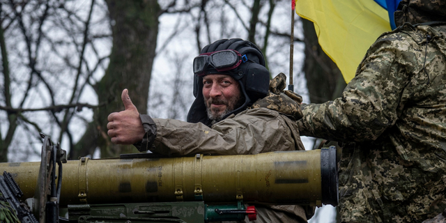 A Ukrainian soldier rides atop an armored fighting vehicle in eastern Ukraine. 