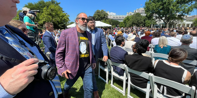 Manuel Oliver, the father of a child who died during the Parkland, Florida, school shooting, is escorted out of an event on the White House South Lawn after interrupting President Biden's remarks on gun control. 