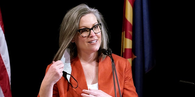 Arizona Secretary of State Katie Hobbs removes her face covering as she addresses members of Arizona's Electoral College before its casting of votes in Phoenix, Ariz., Dec. 14, 2020. 