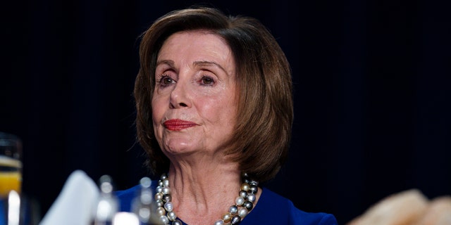 House Speaker Nancy Pelosi listens as President Donald Trump speaks at the 68th annual National Prayer Breakfast, Feb. 6, 2020, in Washington.