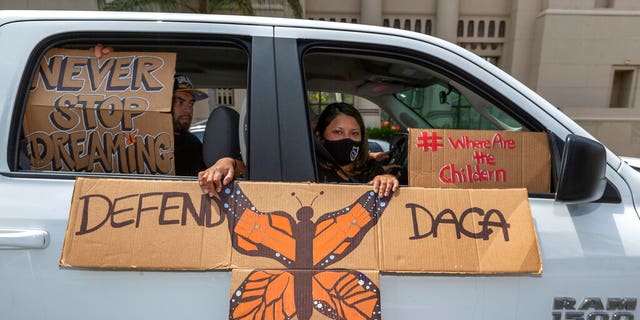 FILE - In this June 18, 2020, file photo, people hold signs during a vehicle caravan rally to support the Deferred Action for Childhood Arrivals Program (DACA), around MacArthur Park in Los Angeles.