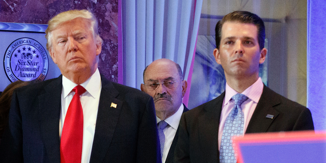 FILE - In this Jan. 11, 2017, file photo, Allen Weisselberg, center, stands between President-elect Donald Trump, left, and Donald Trump Jr., at a news conference in the lobby of Trump Tower in New York. 