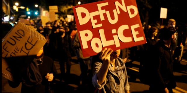 Demonstrators hold a sign reading "Defund the police" during a protest over the death of a Black man, Daniel Prude, after police put a spit hood over his head during an arrest on March 23, in Rochester, New York, U.S. September 6, 2020.