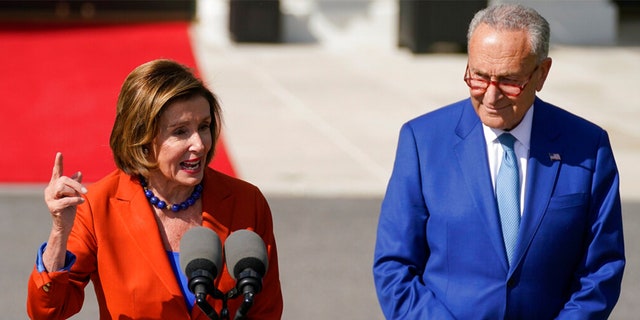 Senate Majority Leader Chuck Schumer of N.Y., listens as House Speaker Nancy Pelosi of Calif., speaks during an event.