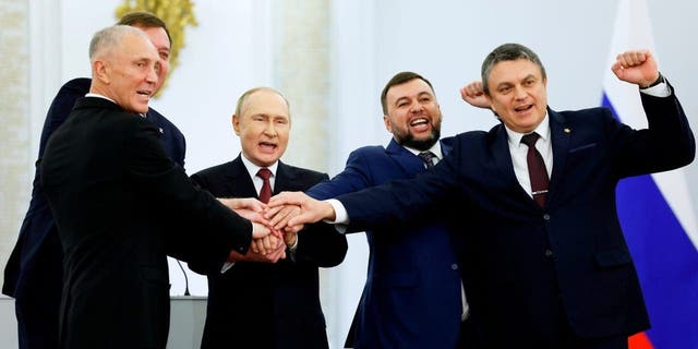 From left, Moscow-appointed head of Kherson Region Vladimir Saldo, Moscow-appointed head of Zaporizhzhia region Yevgeny Balitsky, Russian President Vladimir Putin, Denis Pushilin, leader of self-proclaimed Donetsk People's Republic and Leonid Pasechnik, leader of self-proclaimed Luhansk People's Republic pose for a photo during a ceremony to sign the treaties for four regions of Ukraine to join Russia, at the Kremlin in Moscow, Friday, Sept. 30, 2022. The signing of the treaties making the four regions part of Russia follows the completion of the Kremlin-orchestrated "referendums." (Dmitry Astakhov, Sputnik, Government Pool Photo via AP)