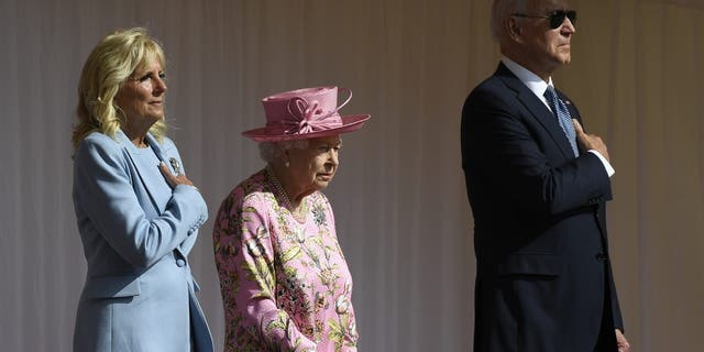 Britain's Queen Elizabeth II stands with US President Joe Biden and First Lady Jill Biden as they listen to the US national anthem at Windsor Castle near London, Sunday, June 13, 2021. (AP Photo/Alberto Pezzali)