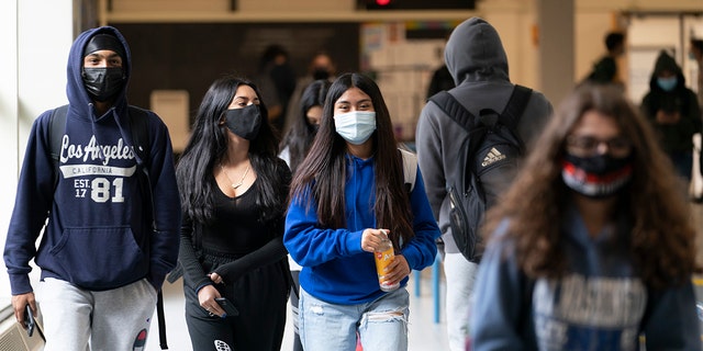 Students walk to classes wearing masks in April 2021 in White Plains, New York.