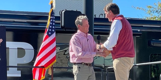 Republican Gov. Glenn Youngkin of Virginia (right) joins GOP Gov. Brian Kemp of Georgia at a Kemp re-election rally on Sept. 27, 2022, in Alpharetta, Georgia