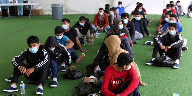 FILE - In this March 30, 2021 file photo, young migrants wait to be tested for COVID-19 at the Donna Department of Homeland Security holding facility, the main detention center for unaccompanied children in the Rio Grande Valley, in Donna, Texas. 