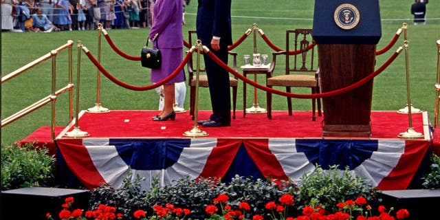 Queen Elizabeth II (left) and U.S. President George H.W. Bush (1925-2018) stand together as the former is welcomed on the White House South Lawn during a state visit May 14, 1991.