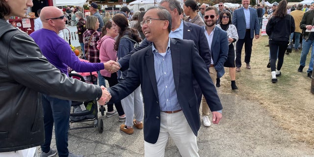 Allan Fung, the Republican nominee in Rhode Island's Second Congressional District, shakes hands with voters at the Scituate Art Festival, on Oct. 10, 2022 in North Scituate, R.I.