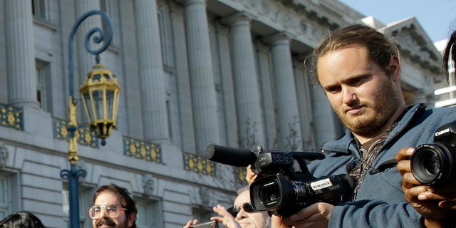 David DePape, right, records the nude wedding of Gypsy Taub outside City Hall on Dec. 19, 2013, in San Francisco.