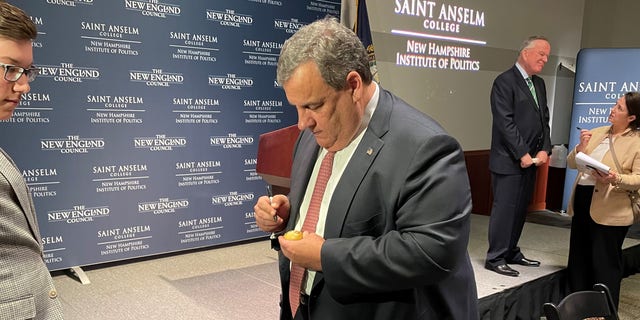 Former New Jersey Gov. Chris Christie signs the iconic wooden eggs after speaking at 'Politics and Eggs' at the New Hampshire Institute of Politics at Saint Anselm College, on March 21, 2022 in Goffstown, N.H.