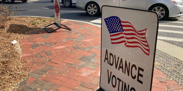 A sign showing the way for voters stands outside a Cobb County voting building during the first day of early voting, Monday, Oct. 17, 2022, in Marietta, Ga. 