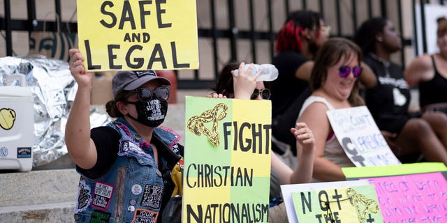 A small group of protesters sits on the steps of the Georgia state capitol after the overturning of Roe v. Wade on June 26, 2022.