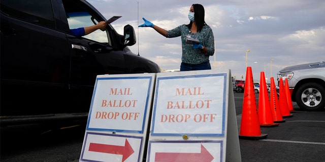 A county worker collects mail-in ballots in a drive-thru ballot drop off area at the Clark County Election Department in Las Vegas.