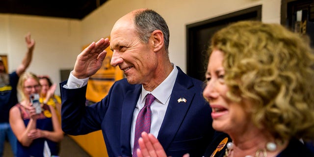 Democratic Senate candidate Mike Franken salutes the crowd as he arrives at an election night event with his wife Jordan Franken on June 7, 2022, in Des Moines, Iowa.