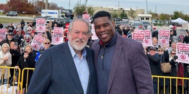 Former Republican Arkansas Gov. Mike Huckabee campaigns with Republican Georgia Senate nominee Herschel Walker on November 16, 2022, in McDonough, Georgia.