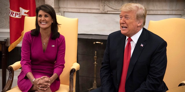 Nikki Haley, United States Ambassador to the United Nations sits next to President Donald Trump in the Oval Office of the White House on October 9, 2018. 