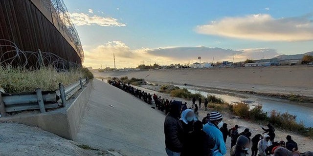 Migrants stand across the Rio Grande from El Paso, Texas. Thousands of migrants have illegally crossed into the city in recent days, prompting concerns from city officials. 