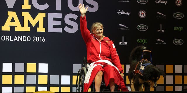 LAKE BUENA VISTA, FL - MAY 09:  Christine Gauthier waves as she receives the Gold Medal in Women's Heavyweight powerlifting finals at the Invictus Games on May 9, 2016 in Lake Buena Vista, Florida. (Photo by Scott Iskowitz/Getty Images for Invictus Games)