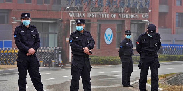 Security personnel gather near the entrance of the Wuhan Institute of Virology during a visit by the World Health Organization team in Wuhan in China's Hubei province on Feb. 3, 2021.