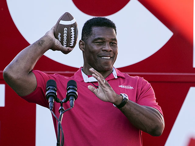 FILE - Republican candidate for U.S. Senate Herschel Walker throws a football to a supporter during a campaign rally Nov. 29, 2022, in Greensboro, Ga. Walker is in a runoff election with incumbent Democratic Sen. Raphael Warnock. (AP Photo/John Bazemore, File)