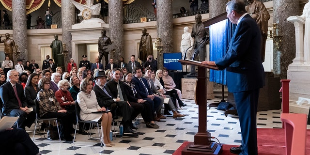 Speaker of the House Nancy Pelosi, D-Calif., seated at left, is joined by her husband Paul Pelosi as they listen to praise from former Republican Speaker John Boehner, right, during her portrait unveiling ceremony in Statuary Hall at the Capitol in Washington, Wednesday, Dec. 14, 2022. 