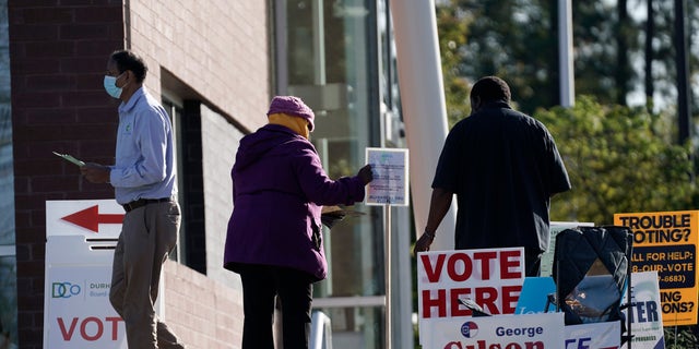 Voters are assisted at a polling location at the South Regional Library in Durham, N.C., Tuesday, Nov. 3, 2020. (AP Photo/Gerry Broome)