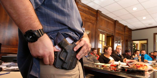 Damon Thueson shows a holster at a gun concealed carry permit class put on by "USA Firearms Training" on Dec. 19, 2015, in Provo, Utah.