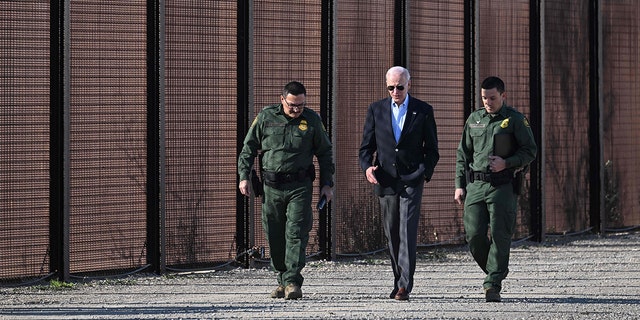 President Joe Biden, center, walks with members of the U.S. Border Patrol along the U.S.-Mexico border fence in El Paso, Texas, on Jan. 8, 2023.