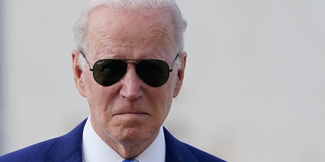 President Biden walks toward reporters.