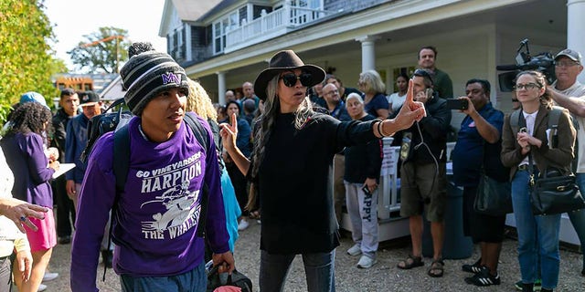 A Venezuelan migrant is led to a bus at St. Andrews Episcopal Church, Sept. 16, 2022, in Edgartown, Massachusetts, on the island of Martha's Vineyard.