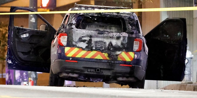 A burned police car sits on the street following a violent protest, Saturday, Jan. 21, 2023, in Atlanta, in the wake of the death of an environmental activist killed after authorities said the 26-year-old shot a state trooper. 