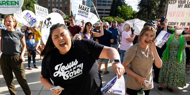 FILE - Rebeca Castro of Fruitland sings and dances to a Christian praise song during an anti-abortion celebration for the overturn of Roe v. Wade, held outside of the Idaho Statehouse in Boise, Idaho on Tuesday, June 28, 2022. On Friday, Aug. 12, 2022, the Idaho Supreme Court ruled that the state's strict abortion bans will be allowed to take effect while legal challenges over the laws play out in court. 