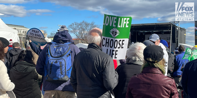 A man stands with a sign at the 2023 March for Life rally in Washington, D.C.