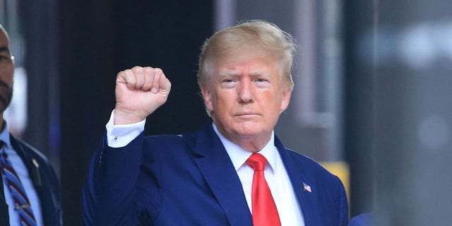 Former US President Donald Trump raises his fist while walking to a vehicle outside of Trump Tower in New York City on August 10, 2022.