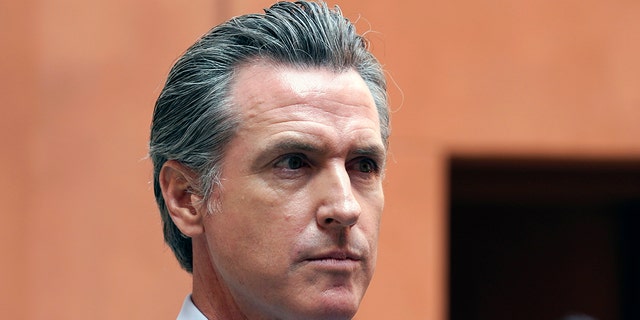 California Gov. Gavin Newsom listens to a question while meeting with reporters