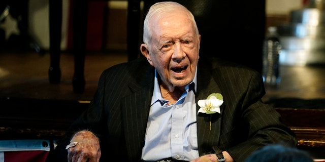 Former President Jimmy Carter reacts as his wife Rosalynn Carter speaks during a reception to celebrate their 75th wedding anniversary Saturday, July 10, 2021, in Plains, Ga.