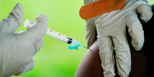 FILE - A health worker administers a dose of COVID-19 vaccine during a vaccination clinic in Reading, Pa. COVID-19 vaccinations are at a critical juncture as companies test whether new approaches like combination shots or nasal drops can keep up with a mutating coronavirus — even though it’s not clear if any change is needed. 