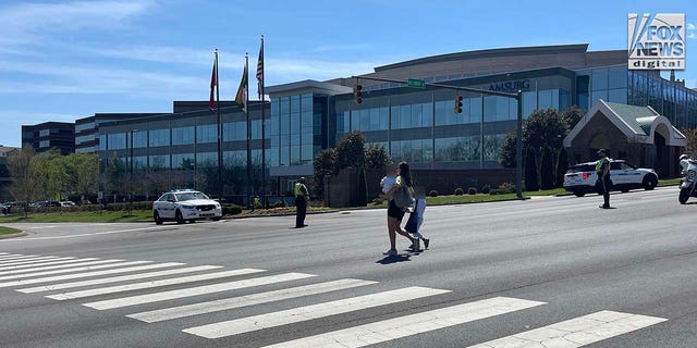 Parents exit with their children after reports of a shooting at The Covenant School in Nashville, Tennessee on Monday, March 27, 2023.