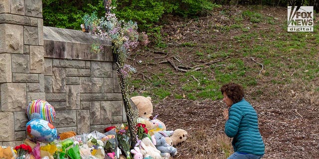 A mourner visits a makeshift memorial Tuesday outside the Covenant School for the six victims who were killed in a mass school shooting in Nashville, Tennessee, on Monday.